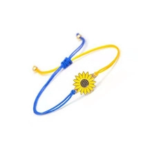 Macro detail of a handmade sunflower bracelet with yellow and blue braided cord