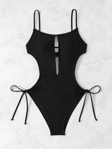 Detailed view of black monokini featuring side cut-outs and adjustable side-tie ribbons