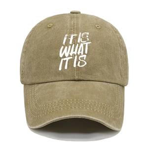 Close-up of khaki washed cotton baseball cap with IT IS WHAT IT IS white printed text