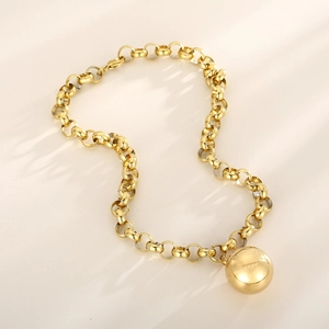 Detailed close-up of a golden metal necklace featuring a bold chain and spherical pendant