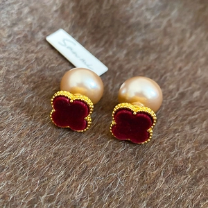 Detail of red velvet clover earrings with gold beading and large champagne pearl backs