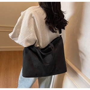 Rear view of model wearing a black large canvas tote bag for daily casual commute