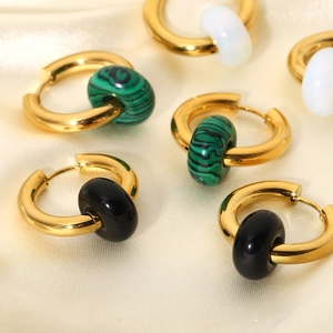 Close-up of gold stainless steel hoop earrings with green, black and white stone beads