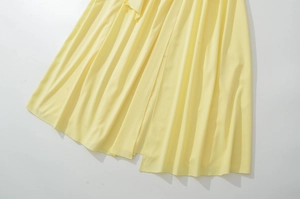 Dettaglio dell'orlo di un abito in chiffon giallo chiaro con trama e pieghe del tessuto