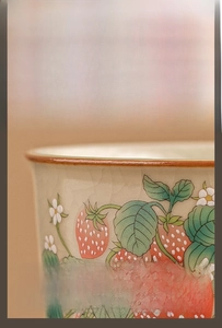 Detail of Ruyao ceramic teacup with strawberry motif and crackle glaze finish