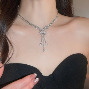 Detail of silver butterfly tassel necklace with zircon stones worn by model on neck