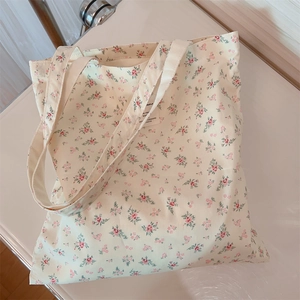 Detailed texture of beige floral cotton canvas tote bag with pink flower patterns