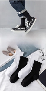 Detail showing breathable mesh texture and ribbed cuffs on black and white cotton crew socks
