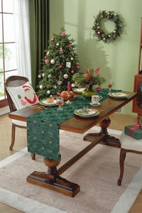 Close-up of dark green table runner with gold Christmas tree embroidery on wooden table