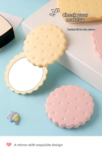 Detail of creative biscuit-shaped folding pocket mirror with wave edges and comb