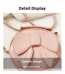 Close-up of pink round crossbody bag featuring large leather bow and gold hardware