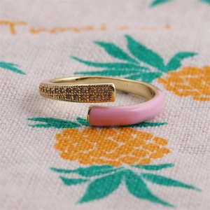 Detailed macro view of gold adjustable ring with pink enamel and sparkling zircon rows