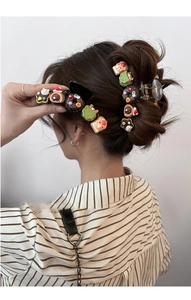 Detail of bear donut hair claw clip featuring cute resin charms on a messy bun hairstyle