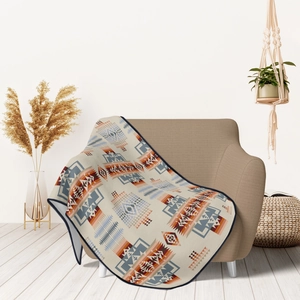 Detail of soft flannel throw blanket with geometric tribal patterns on a cozy sofa