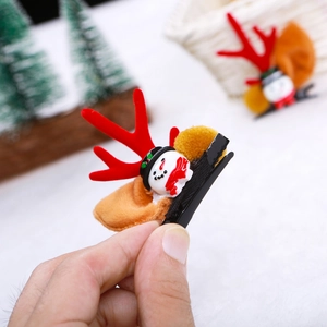 Detail of Christmas reindeer antler hair clip with snowman and plush ball on duckbill clip