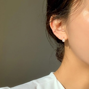 Close-up of minimalist gold hook earrings with elegant 6-8mm round white pearls