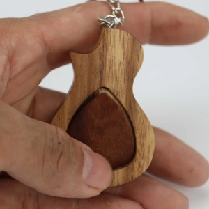 Nahaufnahme eines gitarrenförmigen Plektrum-Etuis aus Holz mit natürlicher Maserung