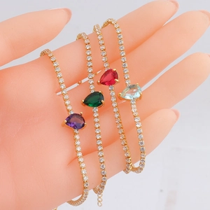 Tennis bracelet set featuring colorful teardrop gemstones in gold plating on model wrist
