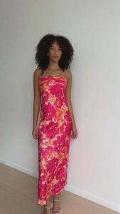 Dettaglio dell'elegante abito in raso rosa con un design a stampa floreale tropicale