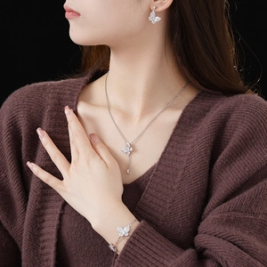 Detail of silver butterfly jewelry set featuring sparkling zircon stones on a model