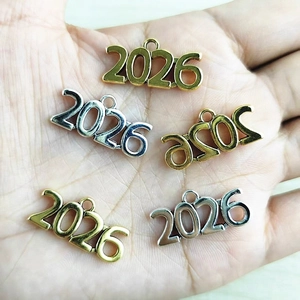 DIY alloy 2026 year charms in gold and silver finish shown on a palm for size