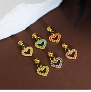 Detailed view of six gold hollow heart charms with multi-colored crystals for DIY jewelry