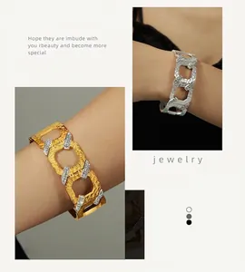 Macro detail of wide chain bracelets in gold and silver with hammered metal texture