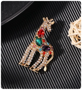 Close-up of colorful rhinestones on a golden giraffe brooch with polished details