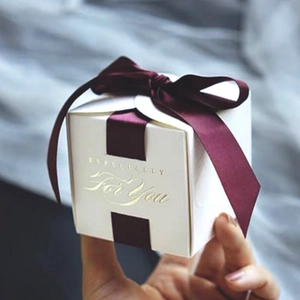 Close-up of white gift box with deep red ribbon and gold Especially For You text