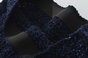 Vista macro del tessuto a maglia blu scuro con fascia elastica nera in vita
