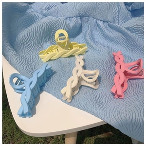 Matte macaron shark hair clips in yellow, blue, cream, and pink with a braided design