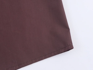 Detailed close-up of dark brown fabric showing plain weave texture and precise stitching