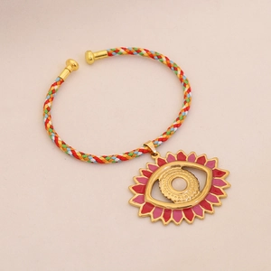 Detail of a braided bracelet with a colorful sunflower eye charm and golden hardware
