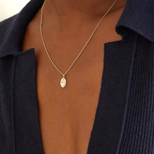 Irregular oval zircon gold plated necklace shown on model with dark blue knitwear