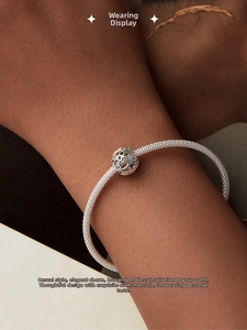 Detail of silver S925 snake chain bracelet with hollow floral charm on a wrist