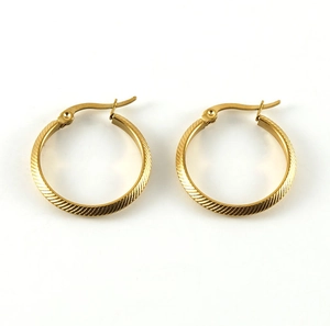 Close-up of gold titanium steel hoop earrings featuring intricate diagonal textured stripes