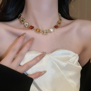 Macro shot of a vintage gold necklace with multi-color rectangular crystal gems