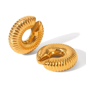Close-up of golden C-shaped ear cuff with textured spiral pattern and mirror finish