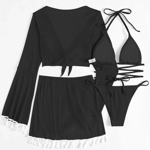 Detail of four-piece black bikini set featuring white tassel trim and bell sleeve cover-up
