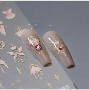 Macro shot of gold bronzing nail art stickers with crown patterns on acrylic nails