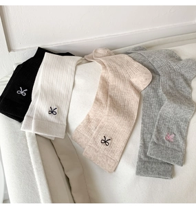 Detail shot of four rib-knit cotton socks with bow embroidery in black, white, and grey