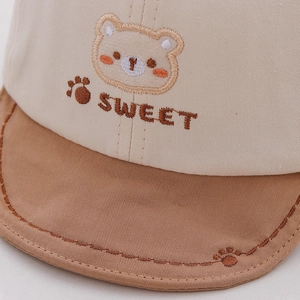Close-up of cute cartoon bear embroidery and sweet text on baby cotton baseball cap