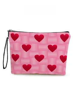 Macro view of pink checkered makeup bag featuring red heart patterns and black lanyard