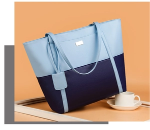 Two-tone blue soft leather tote bag with elegant metallic accent on stylish table setting