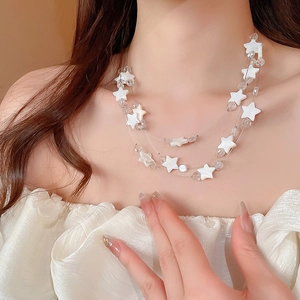 Détail d'un collier multicouche étoile en coquillage avec perles sur le cou de la femme