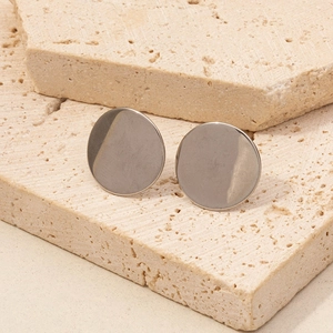 Detail view of round minimalist 304 stainless steel stud earrings on natural stone