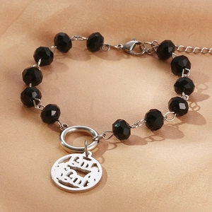 Detail of beaded bracelet with black faceted crystals and round Chinese lucky charm