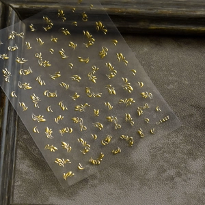Makroaufnahme von 5D-geprägten goldenen Ranken-Nagelaufklebern mit der Seriennummer TO 1427