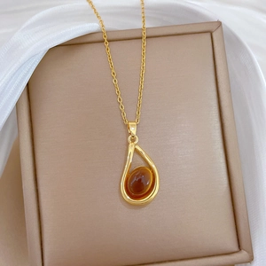 Luxurious gold necklace with amber water-drop pendant on brown leather gift box