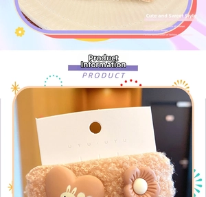 Close-up of plush peach-pink hair clip with cute heart, rabbit, and floral details